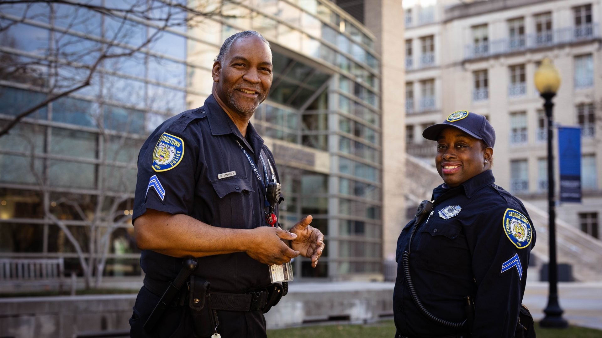 two officers in DPS uniforms, one male and one female, smile and turn slightly towards camera on the Eleanor Holmes Norton Green